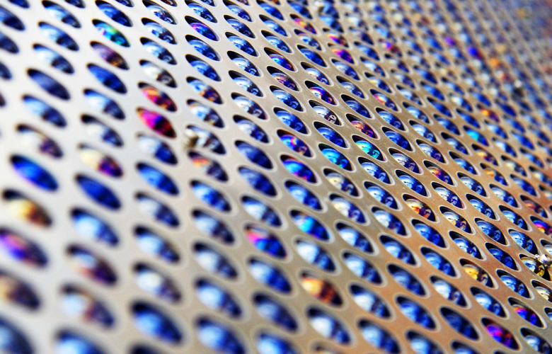 A silver and blue metal sheet with multiple holes