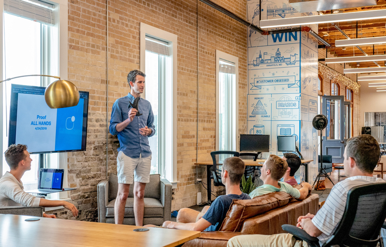 A leader addressing a group of colleagues in a modern office setting