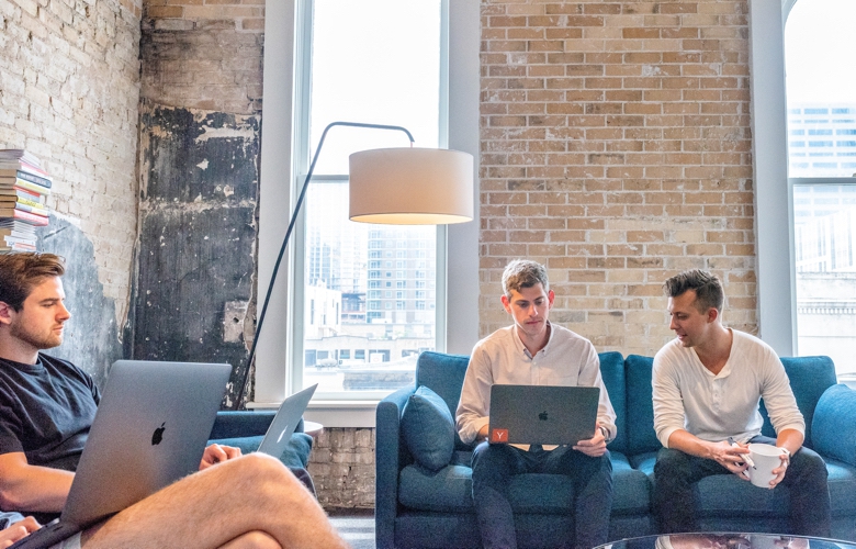 Four agency staff working on laptops in a city office